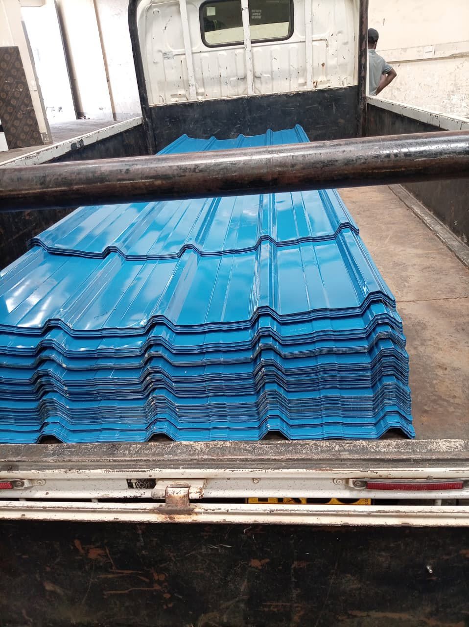 Royal blue box-profile glossy mabati neatly stacked inside a delivery truck bed